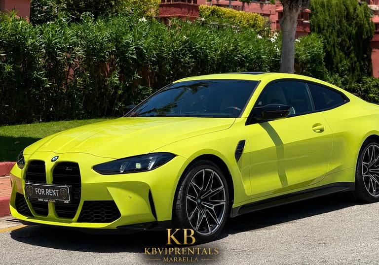 Yellow BMW M4 luxury sports car for rent in Marbella, parked on a sunny street near green hedges.