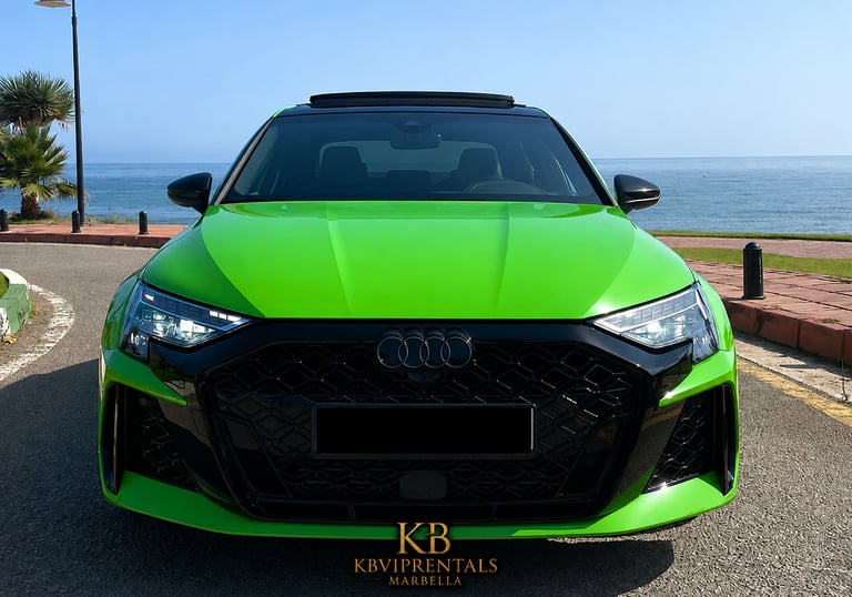 Front view of a lime green Audi RS3 luxury rental car parked by the sea in Marbella.