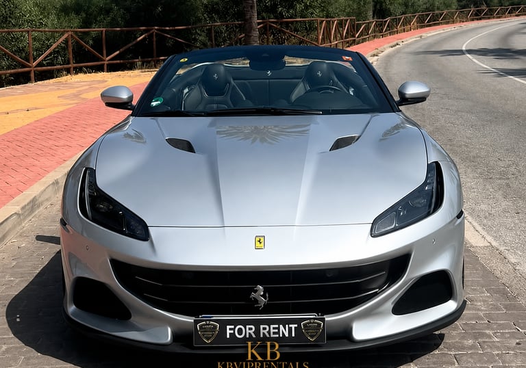 Silver Ferrari Portofino luxury convertible car for rent parked on a sunny street in Marbella.