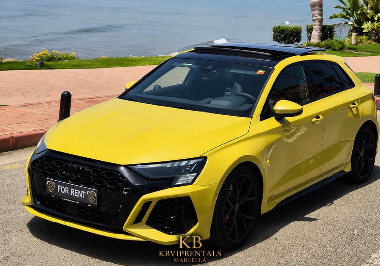 Yellow Audi RS3 luxury car rental parked by the ocean in Marbella with panoramic sunroof open.