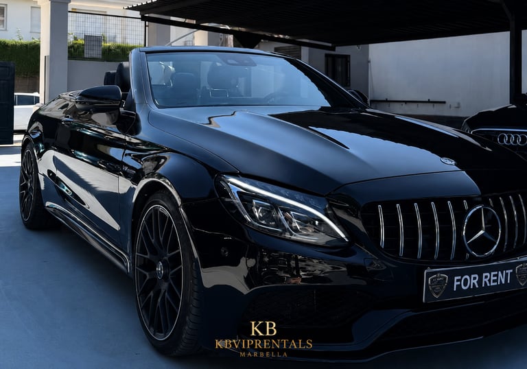 A sleek black Mercedes-Benz AMG convertible luxury car rental parked in Marbella.
