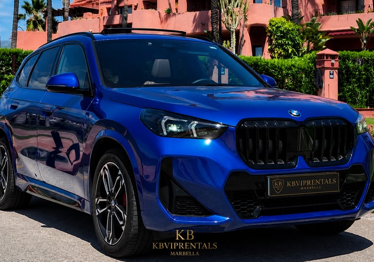 Blue BMW SUV rental car parked at a luxury resort in Marbella with KB VIP Rentals logo.