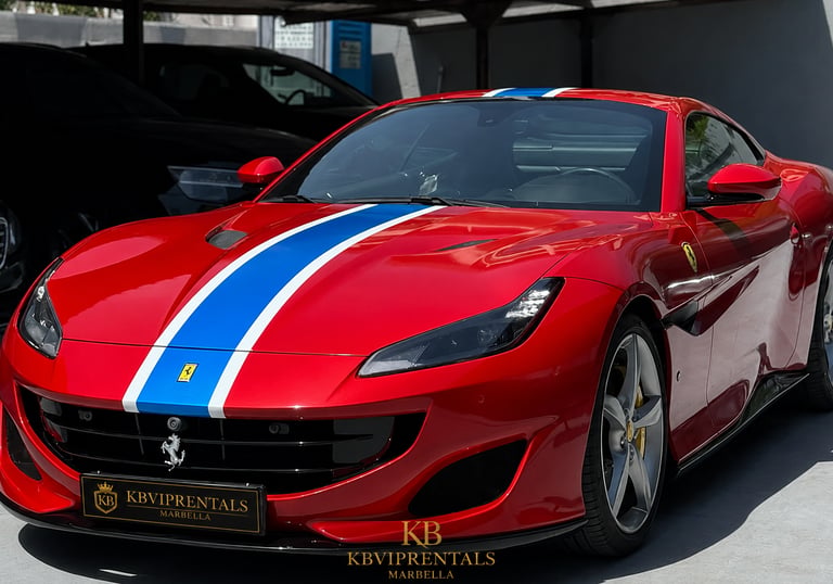 Red Ferrari Portofino luxury rental car with blue and white racing stripes parked in Marbella.