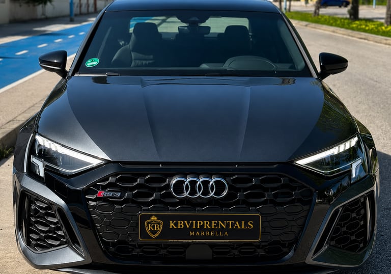 Front view of a dark grey Audi RS3 luxury car rental in Marbella with a honeycomb grille.