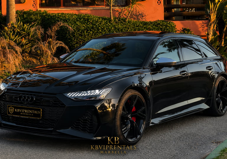 Sleek black Audi RS6 Avant luxury car rental parked in Marbella at sunset.