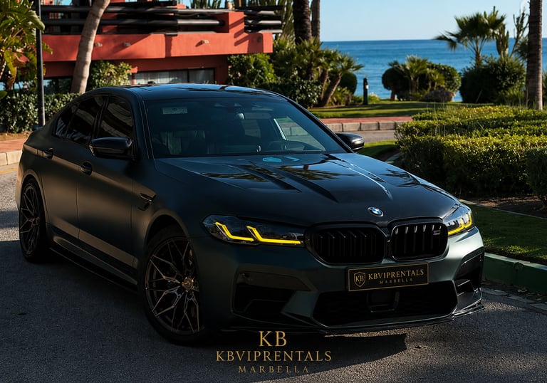 Matte black BMW M5 luxury rental car parked near a tropical Marbella beach resort.