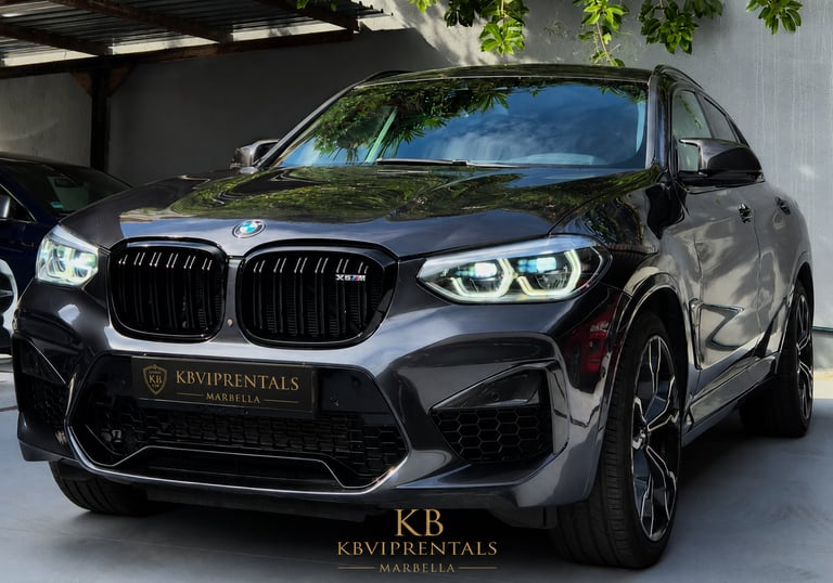 Luxury grey BMW X5 M rental car parked at KB VIP Rentals Marbella showroom.