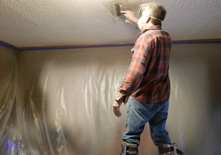 Daryl scraping the popcorn off of a ceiling.