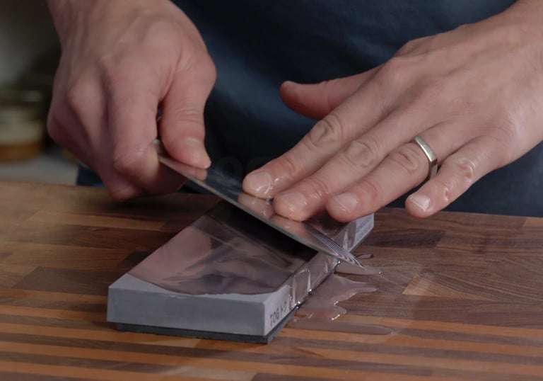 a person is cutting a piece of paper with a knife