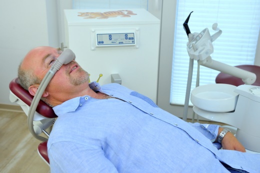 a man in a dentist's chair with a mask on his face