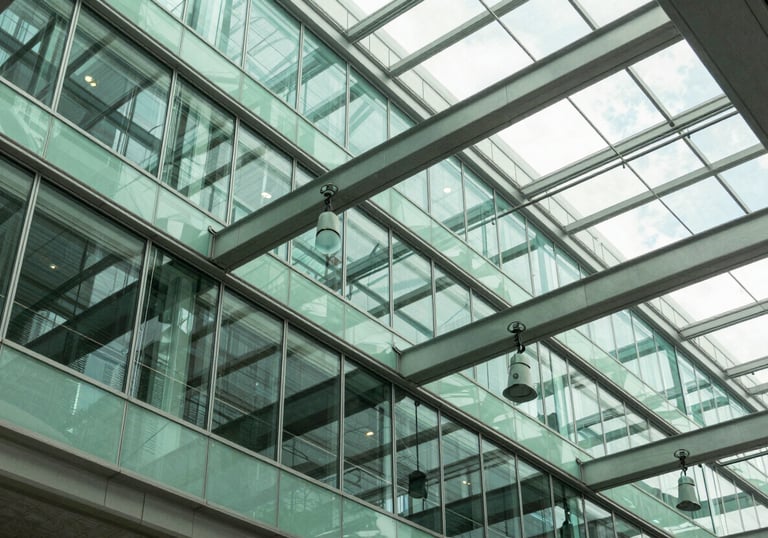 An abstract photography shot of a modern glass and steel architectural ceiling in a US tech office, with Mint Green reflections and sophisticated lighting.