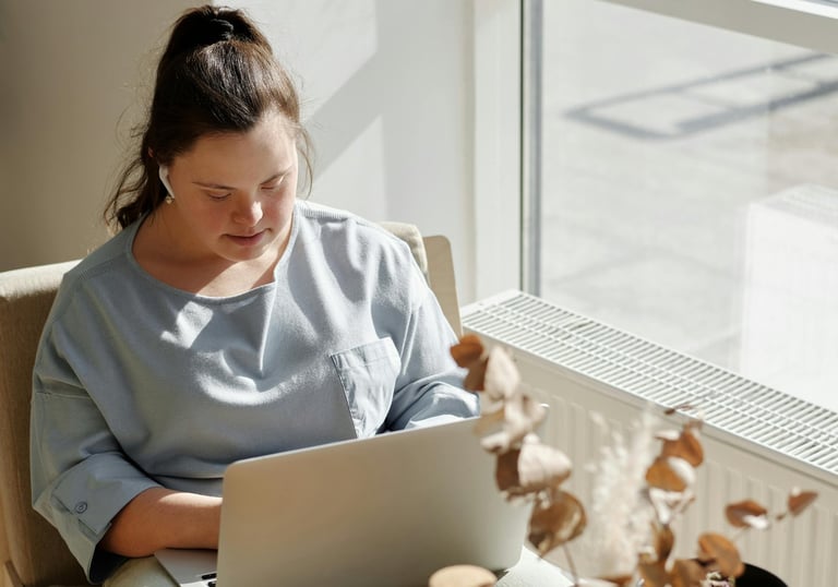 a woman sitting in a chair with a laptop computer