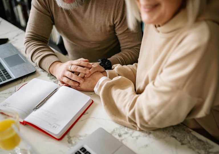 a man and woman holding hands over a notebook