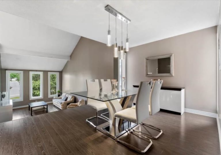 a dining room with a glass table and chairs