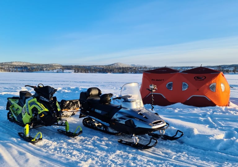 Snowmobiles and two ice fishing tents.