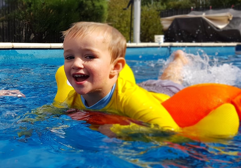 a young child on a yellow inflatable in a pool