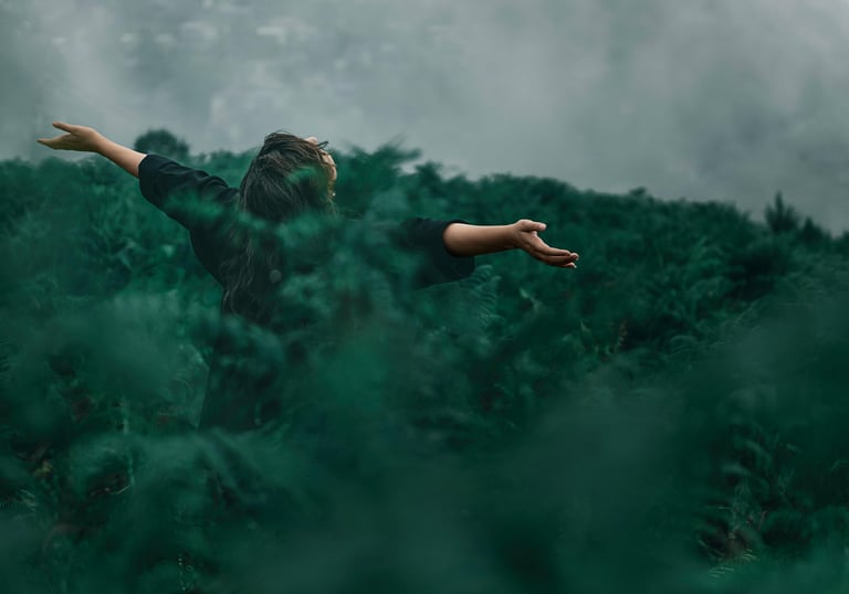a woman standing in a field with her arms outstretched out