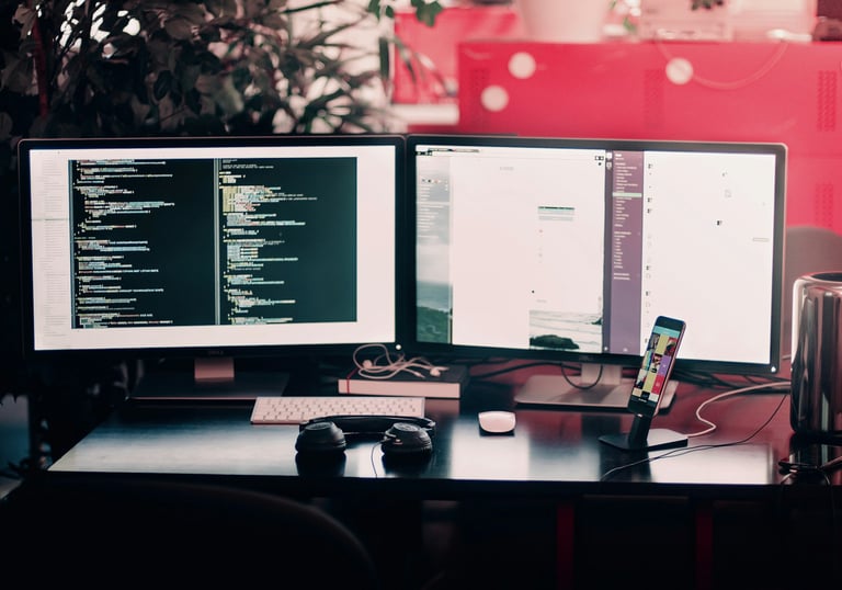 a desk with two monitors and a keyboard