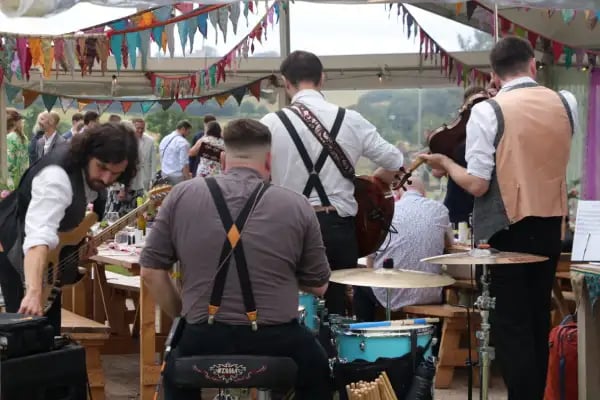 High-energy Devon ceilidh band Rowans leading a festival-style barn dance at a summer wedding