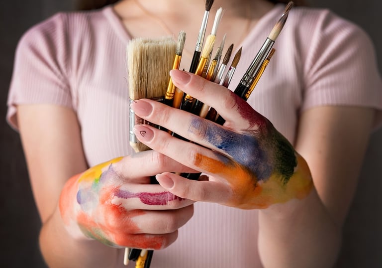 artista con pinceles y manos con pintura