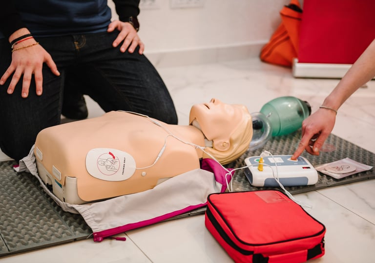 Close up image of CPR mannequin with an AED trainer next to it
