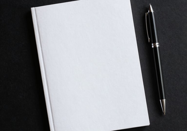 A sleek black notebook with gold embossed logo resting beside a fountain pen.