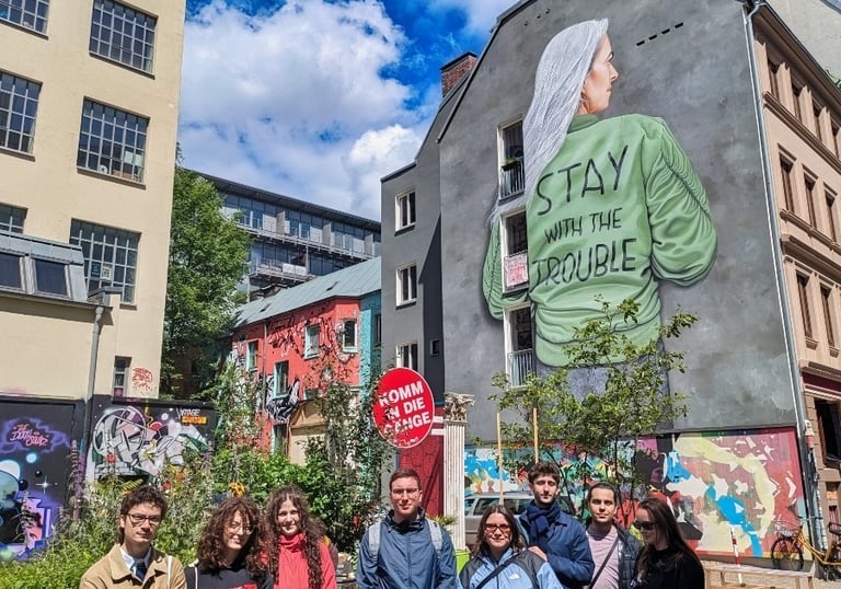 Street art mural in Hamburg with “Stay with the trouble” and group, Graffiti und urbane Kunst Szene in der Stadt