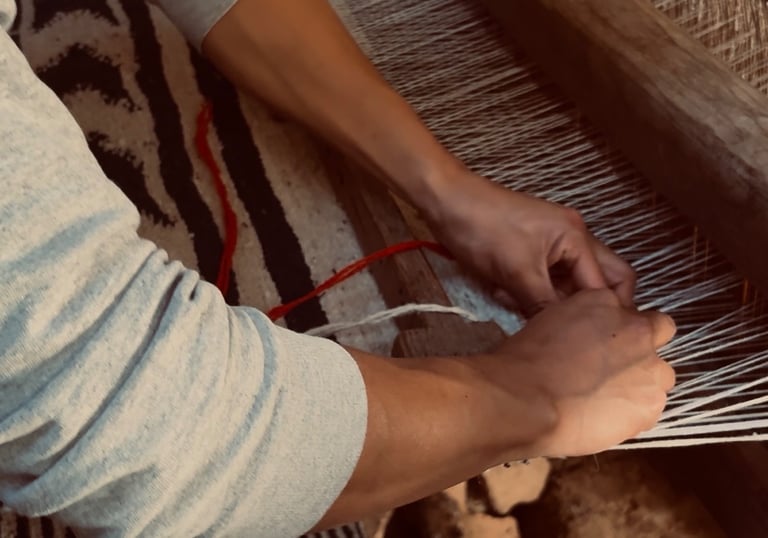 Un artesano tejiendo a mano un tejido de lana estampado en un telar de madera tradicional.