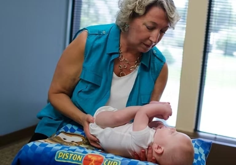 Dr. Naas performing a gentle chiropractic exam on an infant while supporting the baby’s comfort and alignment.