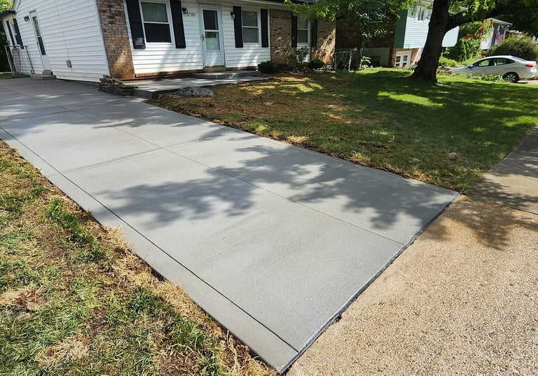 a freshly poured driveway with sidewalk