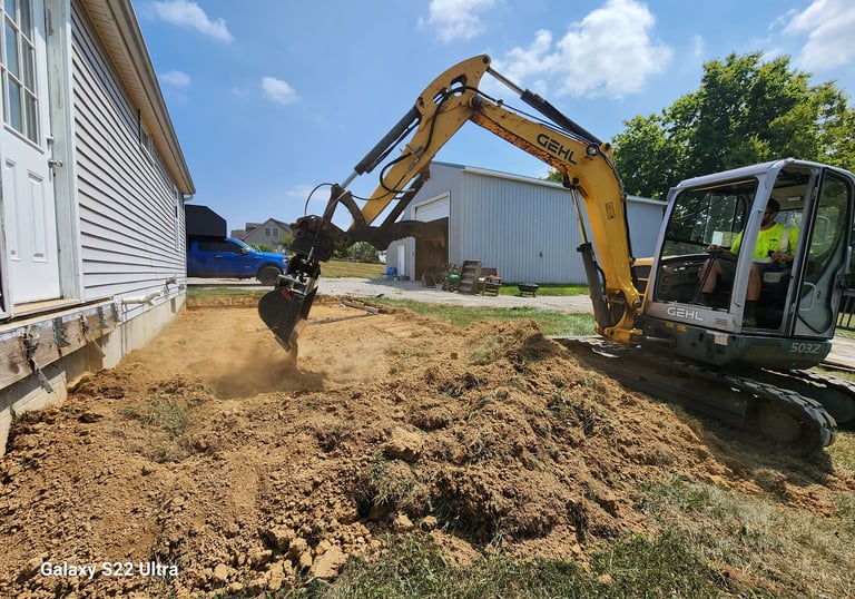 a construction worker is using a machine to remove dirt from the ground