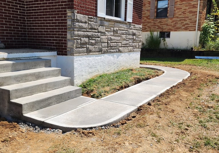 a concrete step up stairs leading to a front door