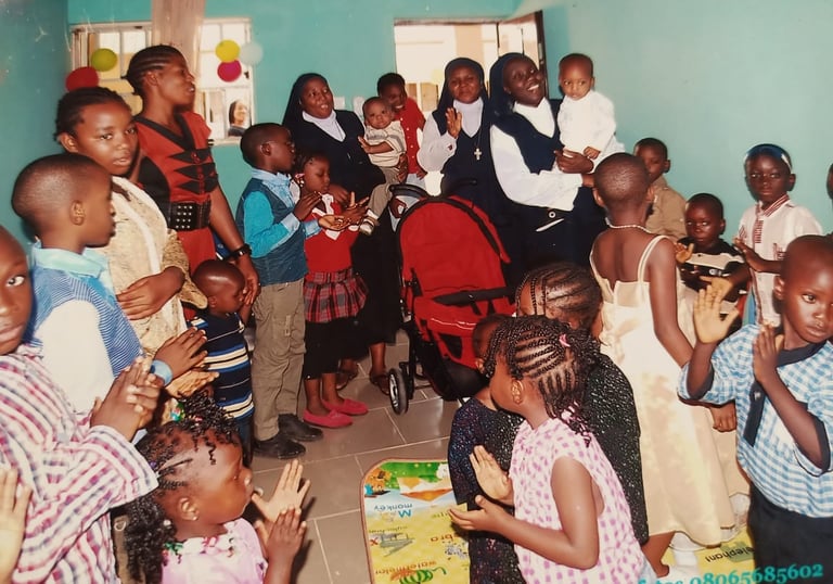 Catholic nuns celebrating with children at an African orphanage or community center gathering.