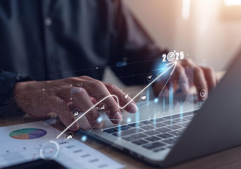 Business professional using a laptop with 2025 growth strategy icons and financial data charts.