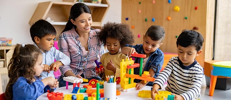 a woman and children playing with blocks and toys