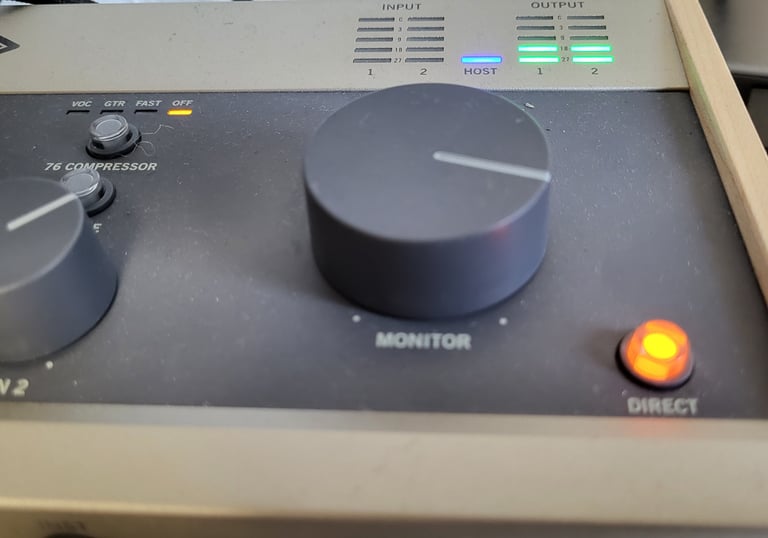Ein Mischpult für die Audioaufnahme, an dem Lämpchen leuchten und ein Regler aufgedreht ist