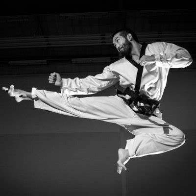 man performing a flying taekwondo kick
