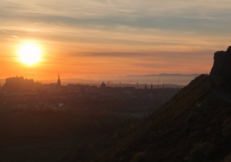 A golden sunset over the Edinburgh city skyline and historic Edinburgh Castle from Salisbury Crags.