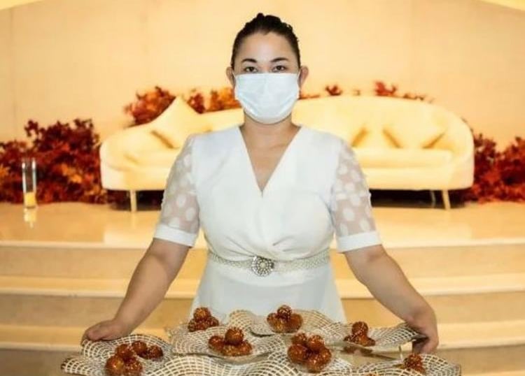 a woman in a white dress and mask covering her face with a mask covering her