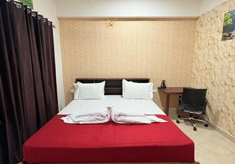 a bed with a red bed and a desk with a computer