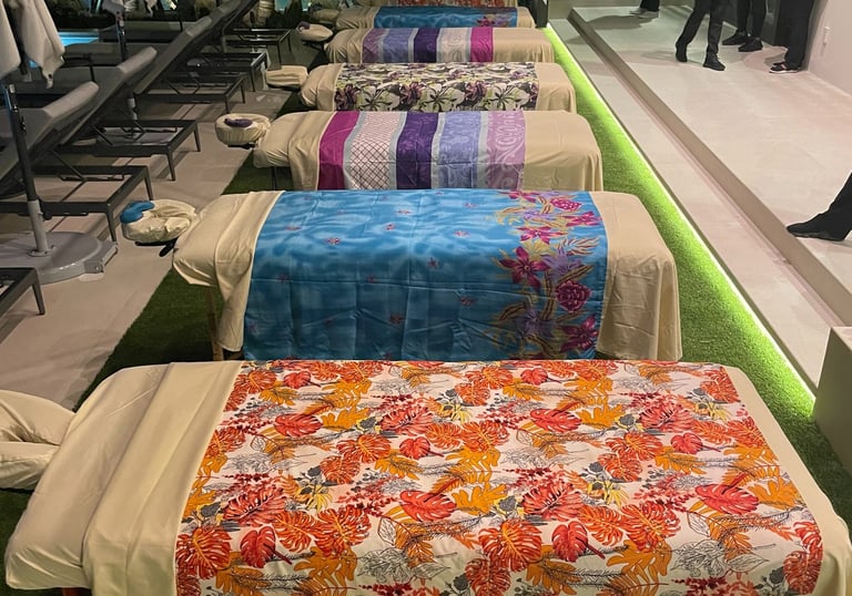 a row of massage beds with colorful bedspreads for a group