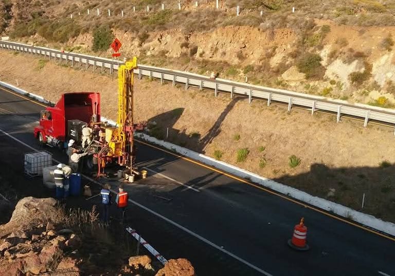 Equipo de ingenieria realizando estudios de mecanica de suelos para construcción de carretera