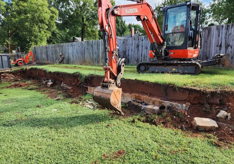 Large excavator removing dirt on excavation project by Storm Valley Landscape