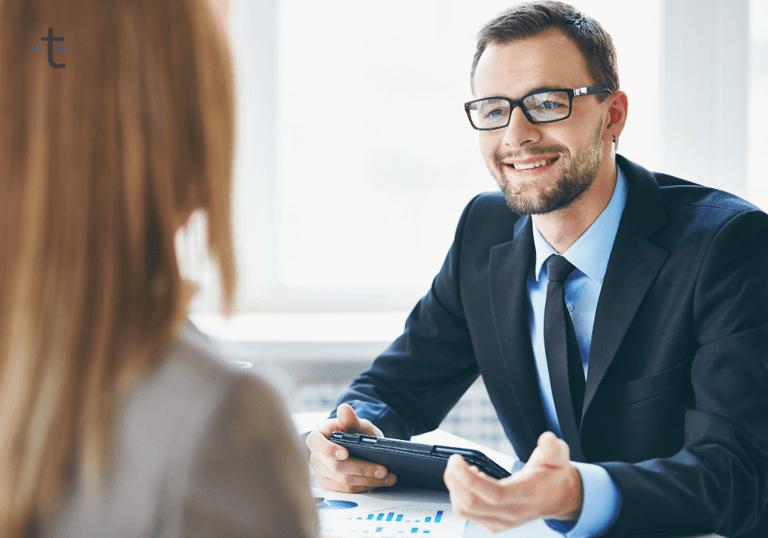 a tcrutr employee of payroll team in a suit and tie is smiling at the client