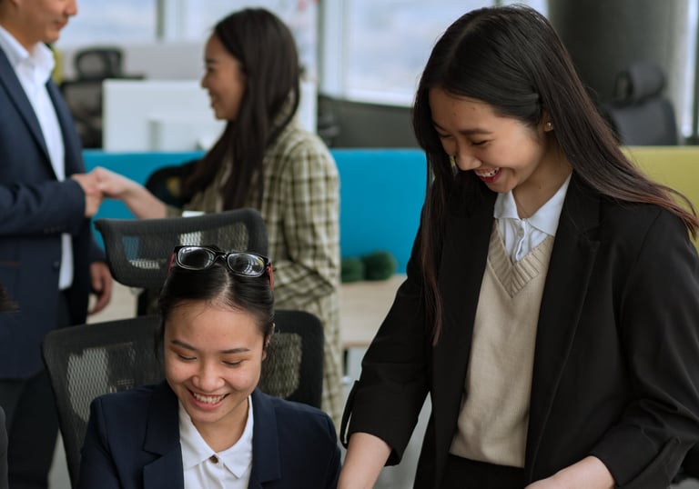 a woman in a suit and tie is smiling at a laptop