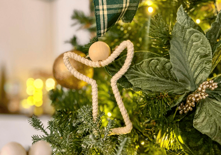 árvore de natal com um anjo ornamentado preso ao galho