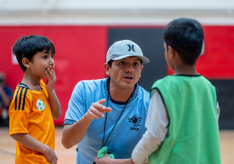 A youth soccer MVB FC coach talking to young players during indoor practice in Mississauga