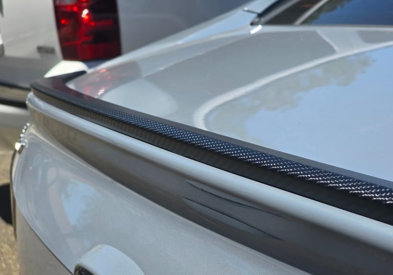 Custom vinyl wrap on rear spoiler, showcasing aesthetic detail and quality finish by Bluemax Tint.