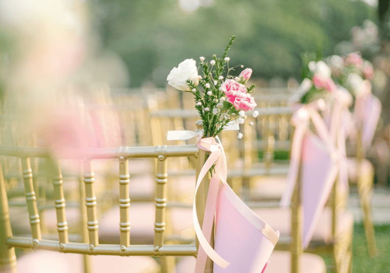 vidéaste de mariage professionnel pas cher peu cher a row of chairs with pink ribbon tied to them