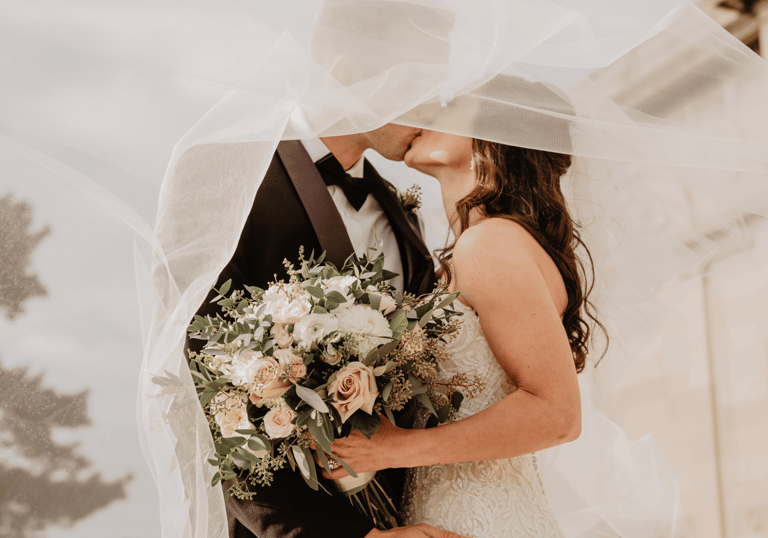 a bride and groom kissing in front of a church